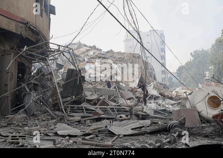 Gaza. 8 octobre 2023. Des Palestiniens inspectent des bâtiments détruits à la suite d’une frappe aérienne israélienne dans la ville de Gaza le 8 octobre 2023. Le nombre de morts des frappes aériennes israéliennes à Gaza est passé à 313, dont 20 enfants, et 1 990 autres blessés, selon une mise à jour du ministère de la Santé basé à Gaza dimanche. Au moins 300 Israéliens ont été tués et plus de 1 800 blessés lors de l'attaque du Hamas, selon les chiffres publiés par le ministère israélien de la Santé. Crédit : Rizek Abdeljawad/Xinhua/Alamy Live News Banque D'Images