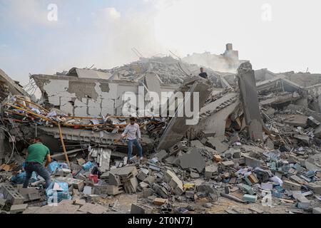Gaza. 8 octobre 2023. Des Palestiniens inspectent des bâtiments détruits à la suite d’une frappe aérienne israélienne dans la ville de Gaza le 8 octobre 2023. Le nombre de morts des frappes aériennes israéliennes à Gaza est passé à 313, dont 20 enfants, et 1 990 autres blessés, selon une mise à jour du ministère de la Santé basé à Gaza dimanche. Au moins 300 Israéliens ont été tués et plus de 1 800 blessés lors de l'attaque du Hamas, selon les chiffres publiés par le ministère israélien de la Santé. Crédit : Rizek Abdeljawad/Xinhua/Alamy Live News Banque D'Images
