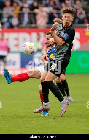 08 octobre 2023, Schleswig-Holstein, Kiel : football : 2e Bundesliga, Holstein Kiel - SV Elversberg, Journée 9, Holstein Stadium. Steven Skrzybski (l) de Kiel et Jannik Rochelt d'Elversberg se battent pour le ballon. Photo : Frank Molter/dpa - REMARQUE IMPORTANTE : conformément aux exigences du DFL Deutsche Fußball Liga et du DFB Deutscher Fußball-Bund, il est interdit d'utiliser ou de faire utiliser des photographies prises dans le stade et/ou le match sous forme de séquences et/ou de séries de photos de type vidéo. Banque D'Images