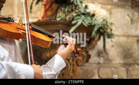 Violoniste caucasien portant des vêtements classiques et se produisant dans un espace clos, église. Spectacle en direct. Gros plan Banque D'Images