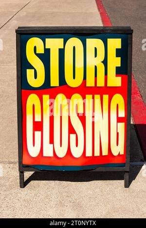 Affiche de fermeture du magasin sur le trottoir devant un magasin de détail qui fait faillite. Banque D'Images