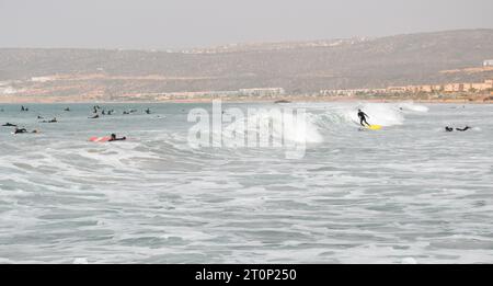 Surfeurs un jour de février sur une plage de sable classique à Tamraght dans la baie de Taghazout, près d'Agadir, Maroc. Banque D'Images