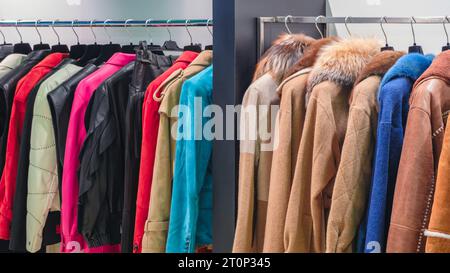 Manteaux multicolores pour femmes, manteaux de fourrure et vestes sur cintres dans le magasin Banque D'Images