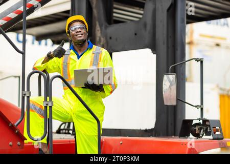 Le docker masculin africain contrôle le chargement de la cargaison de conteneurs au chantier naval de conteneurs d'entrepôt. Employé du personnel maritime et du transporteur. opérateur de chargement de cargaison s Banque D'Images