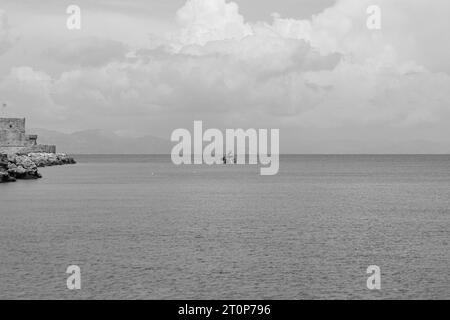 Poseidon sous-marin en bateau rouge à mi-parcours dans l'océan au large de la ville de Rhodes au départ du port de Mandraki en noir et blanc Banque D'Images