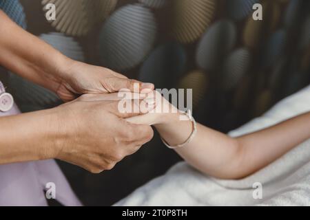 Procédé de massage des mains. Étirement et acupression du tendon de l'articulation du poignet pour la relaxation et la guérison dans le spa pour les soins de santé des femmes asiatiques Banque D'Images