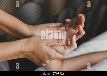 Procédé de massage des mains. Étirement et acupression du tendon de l'articulation du poignet pour la relaxation et la guérison dans le spa pour les soins de santé des femmes asiatiques Banque D'Images