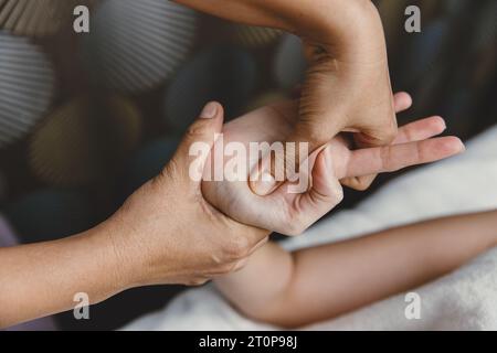 Procédé de massage des mains. Étirement et acupression du tendon de l'articulation du poignet pour la relaxation et la guérison dans le spa pour les soins de santé des femmes asiatiques Banque D'Images