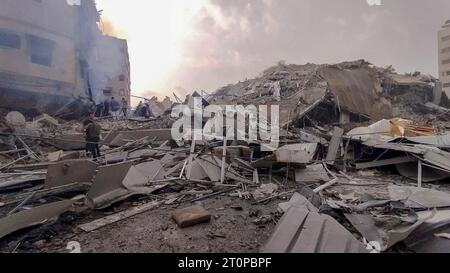 Gaza, Palestine. 8 octobre 2023. (INT) les Palestiniens inspectent les ruines de la tour Watan, tour Palestine, qui ont été détruites par les frappes aériennes israéliennes dans la ville de Gaza. 8 octobre 2023. Gaza, Palestine : les Palestiniens inspectent les ruines de la Tour Watan, Tour Palestine, qui ont été détruites par les frappes aériennes israéliennes dans la ville de Gaza. Les combats ont fait rage entre les forces israéliennes et le mouvement palestinien Hamas le 8 octobre, alors que des centaines de personnes ont été tuées des deux côtés après une attaque surprise contre Israël qui a incité le Premier ministre Benjamin Netanyahu à avertir qu'ils ''embarquaient dans un long et difficile Banque D'Images