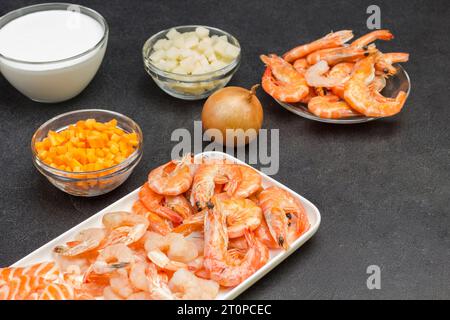 Ingrédients de fruits de mer, crème et légumes pour la cuisson de soupe de chaudrée de palourdes. Une alimentation saine. Fond noir. Vue de dessus Banque D'Images