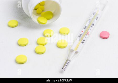 Pilule pour traiter les rhumes et thermomètre. Remèdes contre le froid. Concepts médicaux et médicaments. Vue de dessus Banque D'Images
