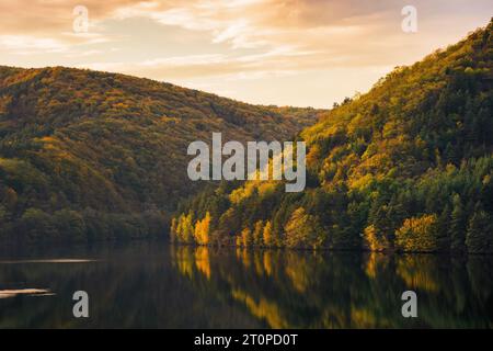 beau paysage de nature avec lac sous un ciel magnifique dans la lumière du soir. paysage de campagne montagneux au coucher du soleil. forêt sur les collines de rivage dans Banque D'Images