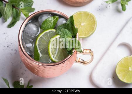 Cocktail alcoolique mule de Moscou dans une tasse de cuivre avec citron vert, menthe et concombre Banque D'Images