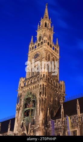Vue sur la tour de l'horloge de la mairie sur la place de Marie illuminée au crépuscule à Munich, Allemagne Banque D'Images
