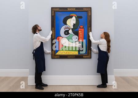 LONDRES, ROYAUME-UNI - 06 OCTOBRE 2023 : des membres du personnel de la galerie tiennent un tableau de Pablo Picasso, Femme à la montre, 1932, estimé à plus de 120 000 000 $ lors d'un photocall à la maison de vente aux enchères Sotheby's présentant les points forts de la collection Emily Fisher Landau à Londres, Royaume-Uni, le 06 octobre 2023. Les œuvres de la collection d’art moderne, d’après-guerre et contemporain seront exposées chez Sotheby’s à Londres du 7 au 11 octobre avant d’être proposées lors de deux ventes aux enchères dédiées à New York en novembre. (Photo de Wiktor Szymanowicz/NurPhoto) Banque D'Images