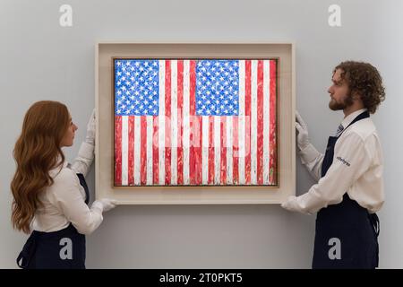 LONDRES, ROYAUME-UNI - 06 OCTOBRE 2023 : des membres du personnel de la galerie tiennent un tableau de Jasper Johns, Flags, 1986, estimé entre 35 et 45 millions de dollars, lors d'un photocall à la maison de vente aux enchères Sotheby's présentant les points forts de la collection Emily Fisher Landau à Londres, Royaume-Uni, le 06 octobre 2023. Les œuvres de la collection d’art moderne, d’après-guerre et contemporain seront exposées chez Sotheby’s à Londres du 7 au 11 octobre avant d’être proposées lors de deux ventes aux enchères dédiées à New York en novembre. (Photo de Wiktor Szymanowicz/NurPhoto) Banque D'Images