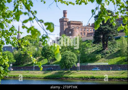 Château d'Inverness avec des feuilles d'arbres et une rivière en face, Écosse Banque D'Images