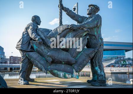 Statue monument de deux hommes portant beaucoup de sacs au port d'Aarhus, Danemark Banque D'Images