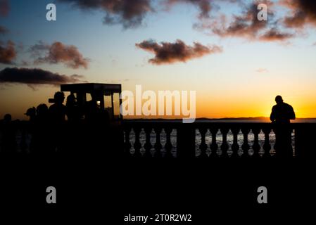 Salvador, Bahia, Brésil - 23 avril 2022 : silhouette d'un groupe de personnes profitant du coucher de soleil dans le quartier de Barra dans la ville de Salvador, Bahia Banque D'Images