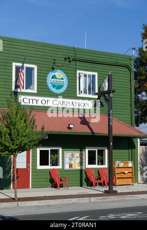 Carnation, WA, États-Unis - 8 octobre 2023 ; City of Carnation immeuble de bureaux en bois vert dans le centre-ville avec signalisation Banque D'Images