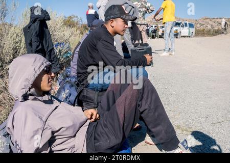 San Diego, États-Unis. 06 octobre 2023. Les migrants attendent dans le désert près de Jacumba Hot Springs pour le traitement de l'immigration. Les migrants traversent la frontière par des lacunes dans le mur frontalier et marchent à travers le désert jusqu’à la zone d’attente. Des migrants rapportent avoir attendu des jours avec de la nourriture et de l’eau fournies par des groupes de bénévoles, 6 octobre 2023. **PAS DE VENTES À SAN DIEGO-SAN DIEGO OUT** crédit : SIPA USA/Alamy Live News Banque D'Images