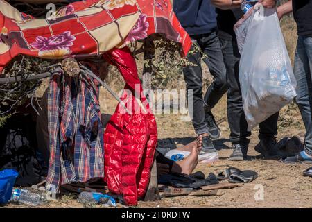 San Diego, États-Unis. 06 octobre 2023. Les migrants attendent dans le désert près de Jacumba Hot Springs pour le traitement de l'immigration. Les migrants traversent la frontière par des lacunes dans le mur frontalier et marchent à travers le désert jusqu’à la zone d’attente. Des migrants rapportent avoir attendu des jours avec de la nourriture et de l’eau fournies par des groupes de bénévoles, 6 octobre 2023. **PAS DE VENTES À SAN DIEGO-SAN DIEGO OUT** crédit : SIPA USA/Alamy Live News Banque D'Images