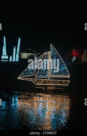 Installations de Noël à partir de guirlandes. Navire de Noël fait de guirlandes brillantes dans le paysage de rue dark.shimmering Banque D'Images