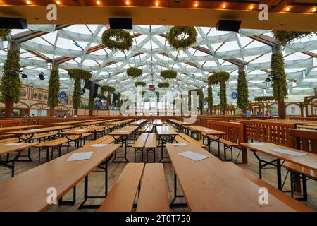 Munich, Allemagne, UE - 18 septembre 2023. Intérieur de tente de bière Hofbräu-Festzelt à l'Oktoberfest Munich. Tables, menus avec quelques personnes en arrière-plan Banque D'Images