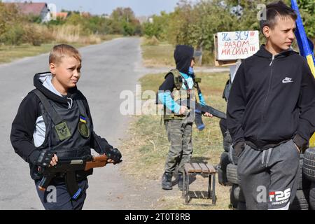 Bilenke, Ukraine. 07 octobre 2023. Des enfants se faisant passer pour des combattants de la défense territoriale vus à leur poste de contrôle du jeu dans le village de Bilenke, dans la région de Zaporizhzhia. Tous les enfants ukrainiens sont profondément touchés par la guerre. Beaucoup ont vu leur vie radicalement changer parce qu’ils ont perdu leur maison ou été forcés d’évacuer. Crédit : SOPA Images Limited/Alamy Live News Banque D'Images