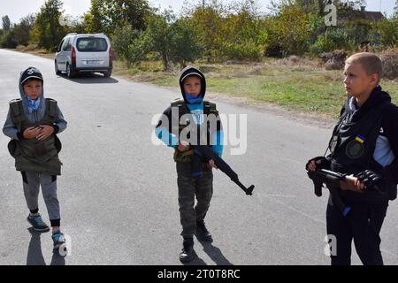 Bilenke, Ukraine. 07 octobre 2023. Des enfants se faisant passer pour des combattants de la défense territoriale contrôlent la circulation à leur poste de contrôle du jeu dans le village de Bilenke, dans la région de Zaporizhzhia. Tous les enfants ukrainiens sont profondément touchés par la guerre. Beaucoup ont vu leur vie radicalement changer parce qu’ils ont perdu leur maison ou été forcés d’évacuer. Crédit : SOPA Images Limited/Alamy Live News Banque D'Images