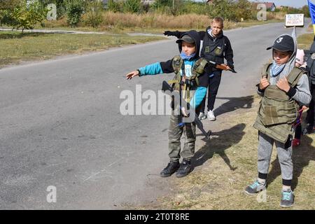 Bilenke, Ukraine. 07 octobre 2023. Des enfants se faisant passer pour des combattants de la défense territoriale contrôlent la circulation à leur poste de contrôle du jeu dans le village de Bilenke, dans la région de Zaporizhzhia. Tous les enfants ukrainiens sont profondément touchés par la guerre. Beaucoup ont vu leur vie radicalement changer parce qu’ils ont perdu leur maison ou été forcés d’évacuer. Crédit : SOPA Images Limited/Alamy Live News Banque D'Images