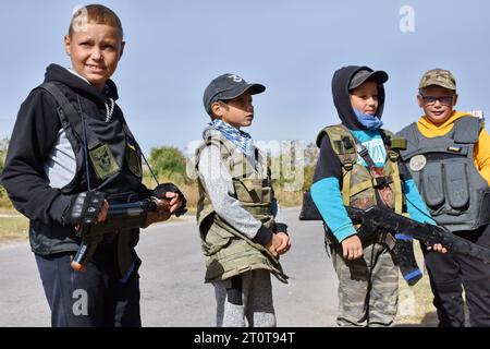 Bilenke, Ukraine. 07 octobre 2023. Des enfants se faisant passer pour des combattants de la défense territoriale vus à leur poste de contrôle du jeu dans le village de Bilenke, dans la région de Zaporizhzhia. Tous les enfants ukrainiens sont profondément touchés par la guerre. Beaucoup ont vu leur vie radicalement changer parce qu’ils ont perdu leur maison ou été forcés d’évacuer. (Photo Andriy Andriyenko/SOPA Images/Sipa USA) crédit : SIPA USA/Alamy Live News Banque D'Images