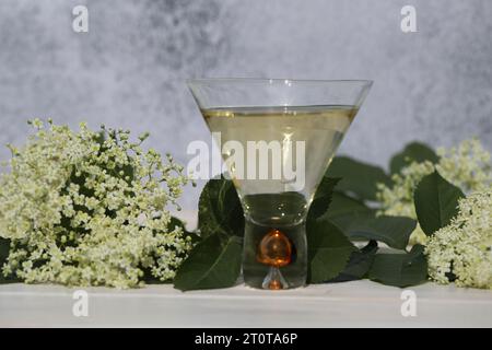 verre original avec liqueur de fleur de sureau avec décoration de fleurs âgées sur fond en bois Banque D'Images