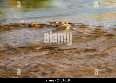 Photographie prise avec la technique de longue exposition de l'eau coulant entre les pierres et les rochers dans la rivière Banque D'Images