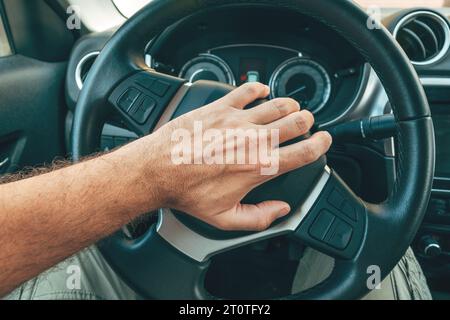 Conducteur en colère et agacé klaxonnant le klaxon de la voiture en appuyant sur le bouton sur le volant, image pov avec mise au point sélective Banque D'Images