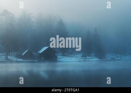 Bohinj Lake Boathhouse au bord de l'eau dans le matin brumeux d'hiver avec cabanes en bois et jetées, focalisation sélective Banque D'Images