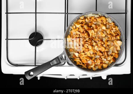 Faire frire les chanterelles avec l'oignon dans une poêle Banque D'Images