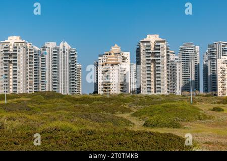 Réserve de Gador, Hadera, Israël, 9 avril 2022 ; le complexe de bâtiments émerge derrière le champ d'herbe verte. Banque D'Images