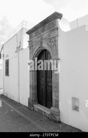 Double porte en bois encadrée avec un cadre en bois plus léger à Lindos sur l'île de Rhodes, Grèce en noir et blanc Banque D'Images