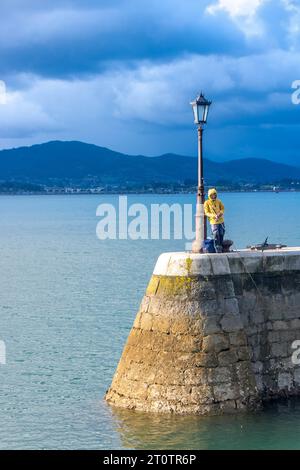 Homme pêchant sur le front de mer de Santander Banque D'Images