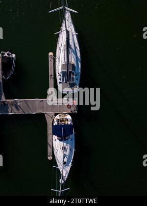 Vue aérienne de dessus d'un port de plaisance de yachts au bord de la mer, orné de yachts élégants, créant une scène maritime pittoresque. Banque D'Images