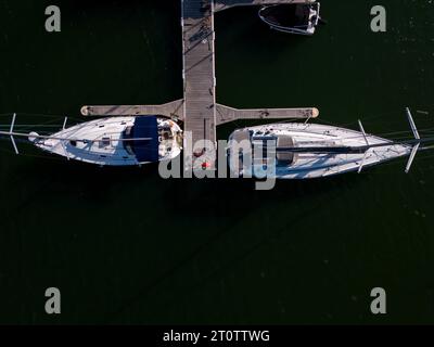 Vue aérienne de dessus d'un port de plaisance de yachts au bord de la mer, orné de yachts élégants, créant une scène maritime pittoresque. Banque D'Images