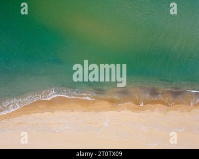 Une vue aérienne de haut en bas d'une plage de sable et de la mer est une vue à couper le souffle, révélant la beauté naturelle de la côte d'un seul et unique RCO Banque D'Images