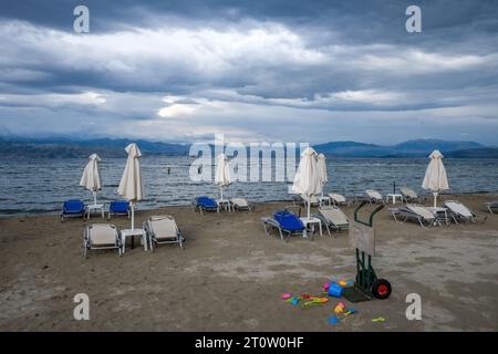 Kalamaki, Corfou, Grèce - chaises longues et parasols sur la plage de Kalamaki dans le nord-est de l'île grecque de Corfou. Dans l'arrière du continent albanais avec le s Banque D'Images