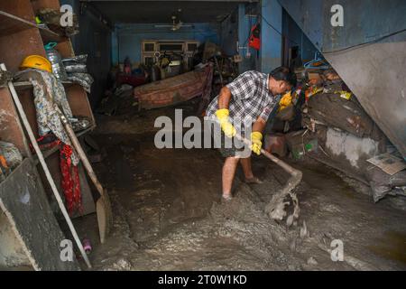 Singtam, Inde. 09 octobre 2023. Sanjay Prasad enlève la boue et le limon de son magasin dans la zone touchée par les inondations le long de la rivière Teesta. Après qu’un lac glaciaire dans le nord-est de l’Inde ait traversé un barrage peu après minuit, emportant des maisons et des ponts et forçant des milliers de personnes à fuir, les sauveteurs ont continué à creuser à travers des débris boueux. Crédit : SOPA Images Limited/Alamy Live News Banque D'Images