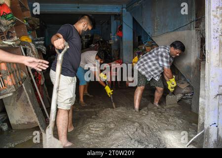 Singtam, Inde. 09 octobre 2023. Sanjay Prasad (à droite) et ses fils retirent le limon et la boue de leur magasin dans la zone touchée par les inondations le long de la rivière Teesta. Après qu’un lac glaciaire dans le nord-est de l’Inde ait traversé un barrage peu après minuit, emportant des maisons et des ponts et forçant des milliers de personnes à fuir, les sauveteurs ont continué à creuser à travers des débris boueux. (Photo de Biplov Bhuyan/SOPA Images/Sipa USA) crédit : SIPA USA/Alamy Live News Banque D'Images