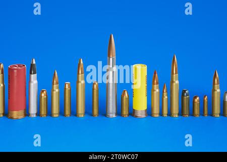 Une énorme rangée de différents types de balles debout sur le sol en béton. Grande variété de calibres de munitions. Pistolet de poing, carabine, automatique, fusil de chasse, et M. Banque D'Images