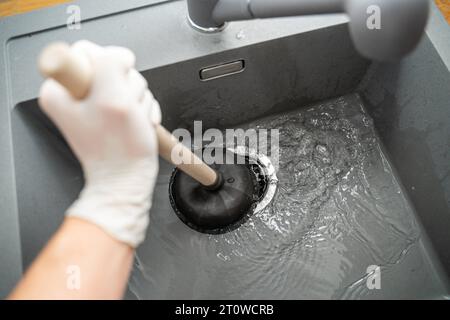 Augsbourg, Bavière, Allemagne. 29 septembre 2023. Workman tente de résoudre un blocage dans un évier avec une cloche d'aspiration *** Handwerker versucht eine Verstopfung in einem Waschbecken mit einer Saugglocke zu lösen Credit : Imago/Alamy Live News Banque D'Images
