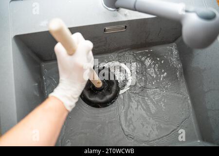 Augsbourg, Bavière, Allemagne. 29 septembre 2023. Workman tente de résoudre un blocage dans un évier avec une cloche d'aspiration *** Handwerker versucht eine Verstopfung in einem Waschbecken mit einer Saugglocke zu lösen Credit : Imago/Alamy Live News Banque D'Images