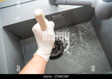 Augsbourg, Bavière, Allemagne. 29 septembre 2023. Workman tente de résoudre un blocage dans un évier avec une cloche d'aspiration *** Handwerker versucht eine Verstopfung in einem Waschbecken mit einer Saugglocke zu lösen Credit : Imago/Alamy Live News Banque D'Images